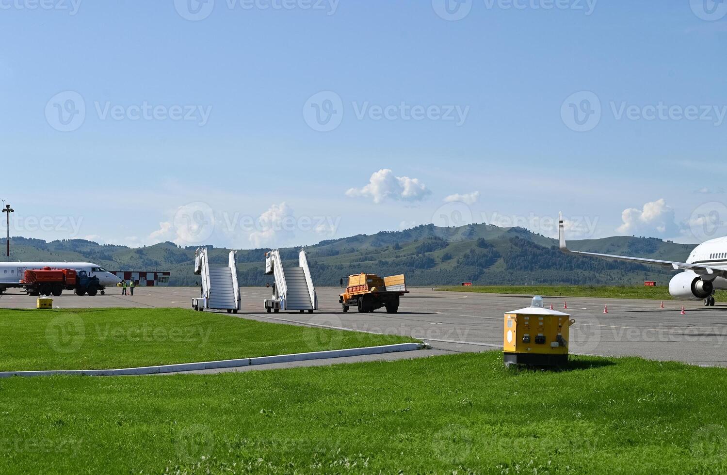 Ladder ladder at the rear entrance of a passenger aircraft, view of the tail and apron of the airport photo
