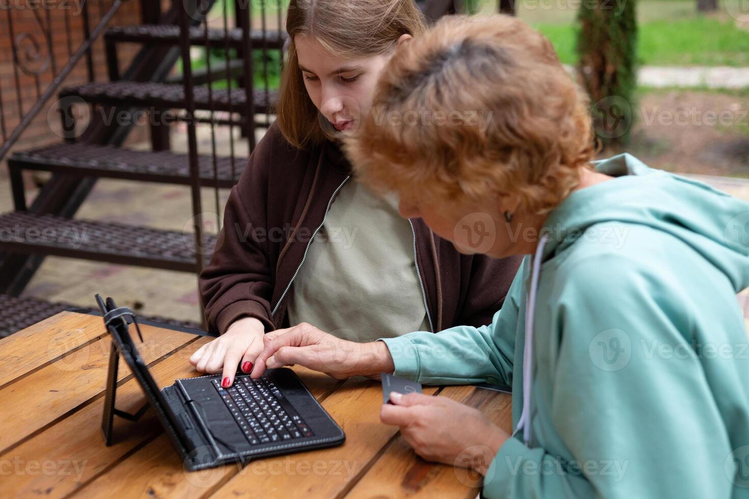 computer awarenesge girl teaches oldegrandmothers to use a laptop at home. social media and modern photo