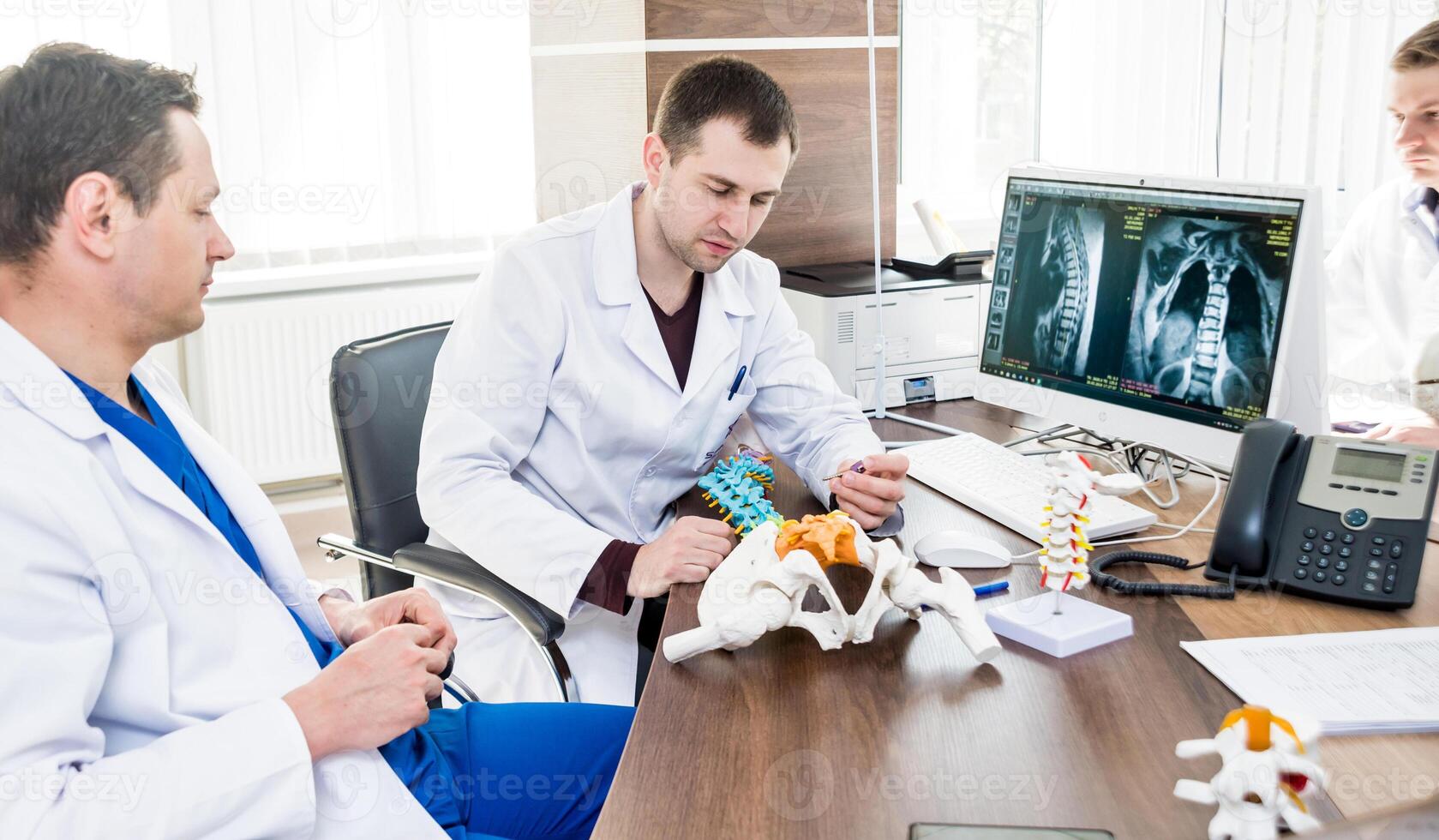 Doctors team having medical council in hospital. Discussing medical issues. Spine fixation systems photo