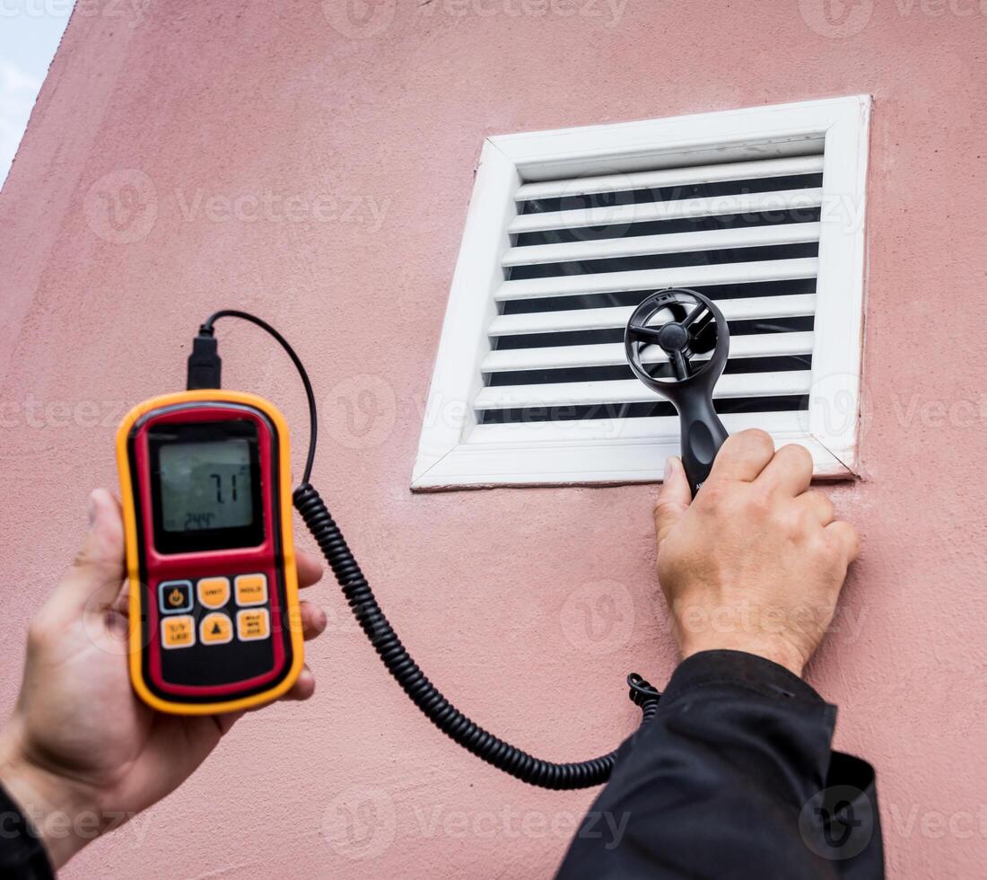 Technician use hand-held anemometer measuring air flowing measurement photo