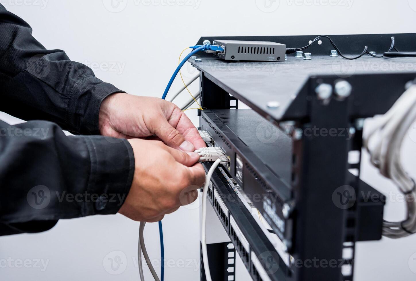 Technician connecting network cables to switches. Connecting cables photo