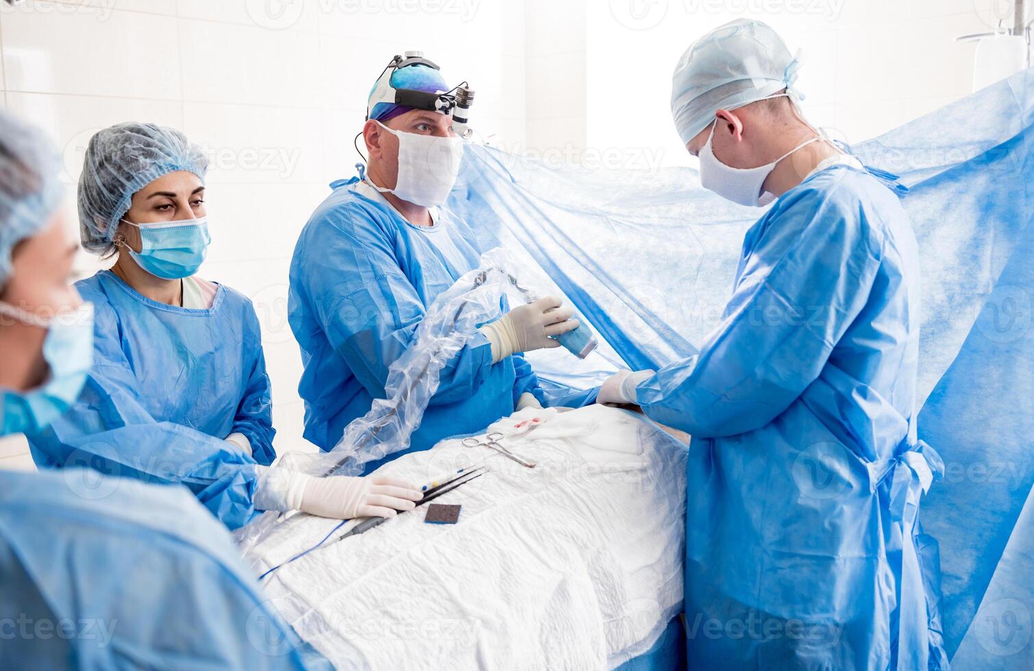 The surgeon uses a portable fluorescence imaging device during breast removal. photo