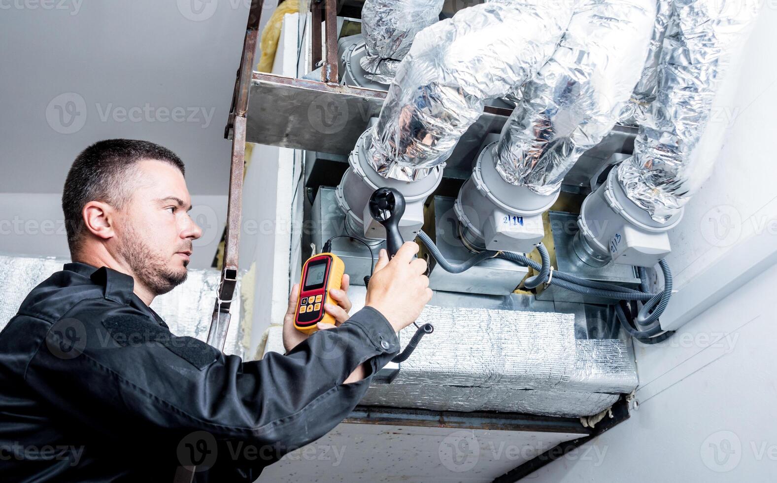 Technician use hand-held anemometer measuring air flowing measurement. photo