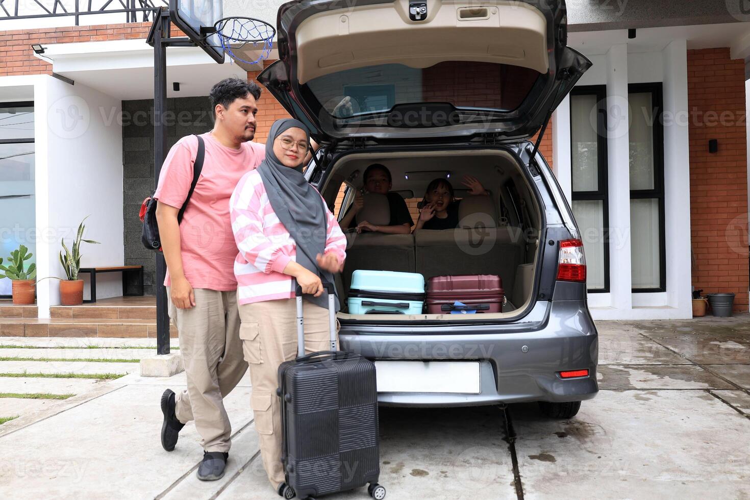 Happy Asian Muslim Family Going on Mudik Road Trip Back Hometown During Eid Mubarak Celebration photo