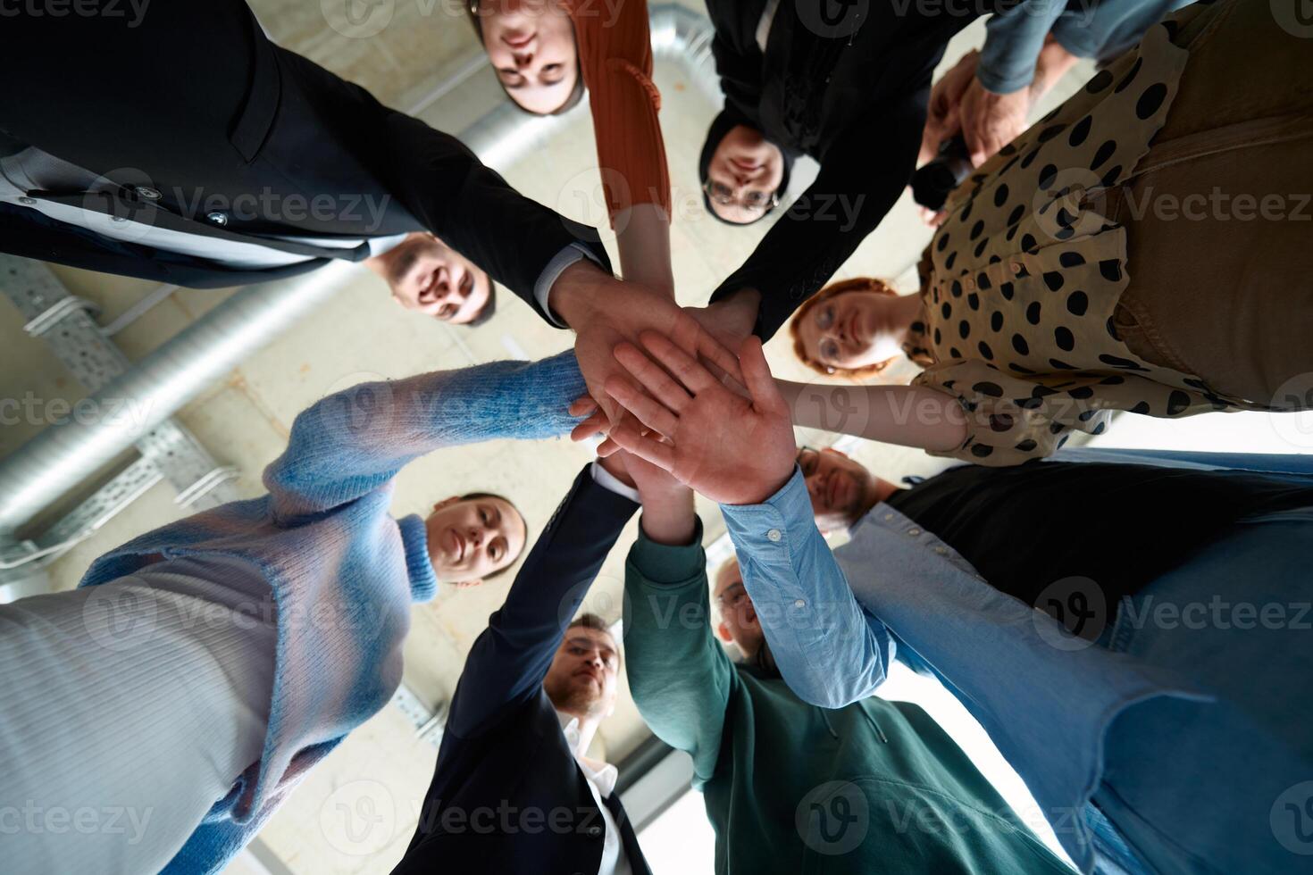 A group of business professionals, captured from a low angle, holding hands to symbolize unity and teamwork. photo
