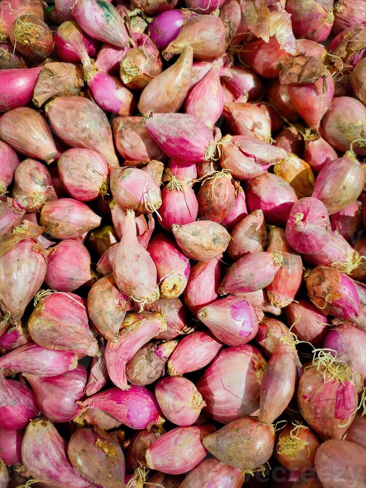 Many red onions create a vibrant and textured backdrop, ideal for food photography, culinary projects, or agriculture related designs photo