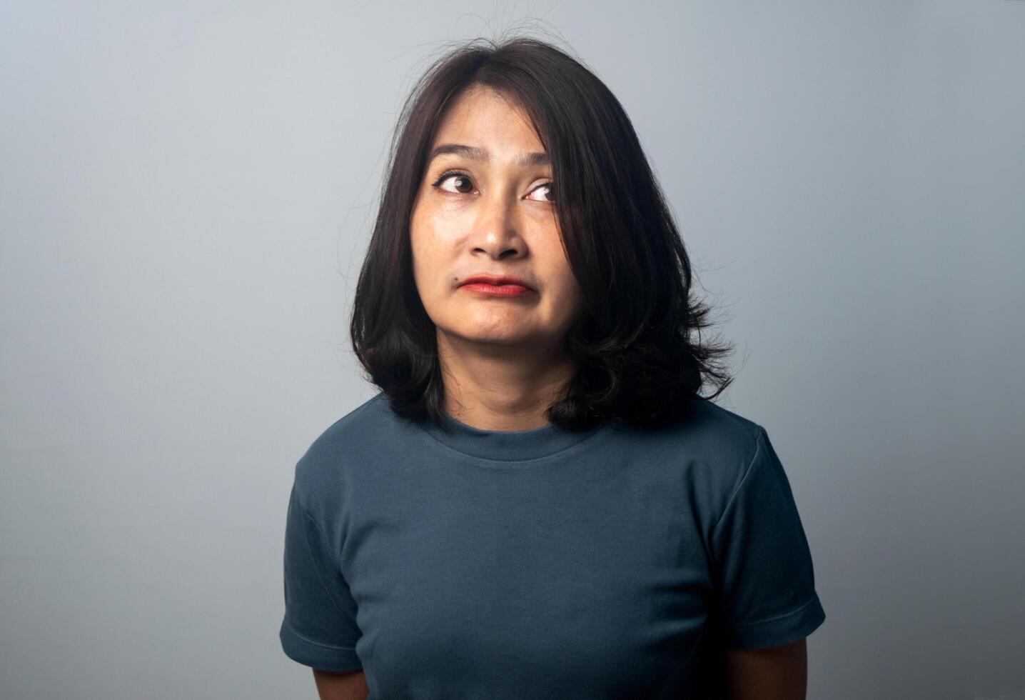 Asian woman standing isolated on grey background surprised face expression and excited face. photo