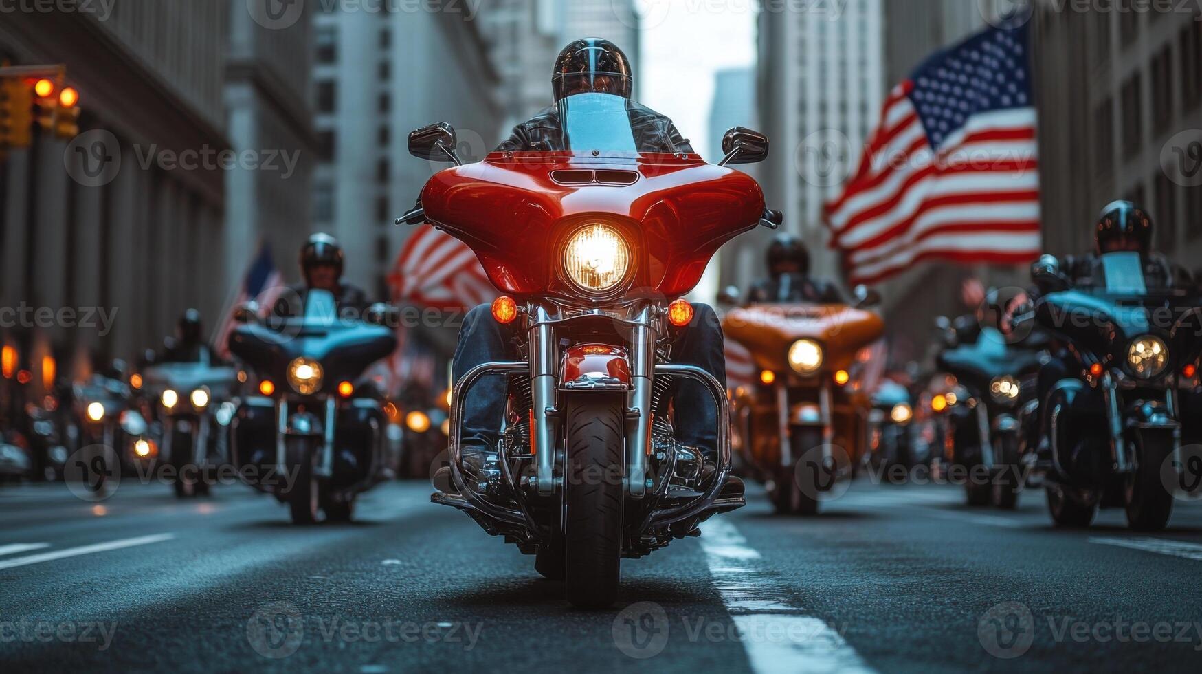 Motorcycle group driving together on road. Bikes with lights on going forward in city. Large American flag waving in background photo