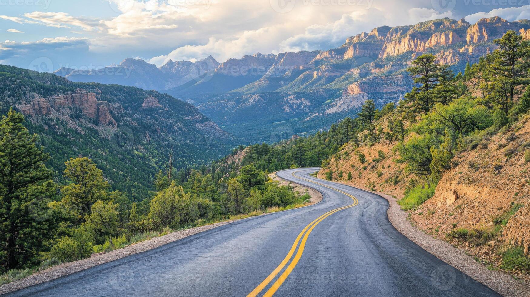 Mountain road winds through trees. Sunlight on peaks and green hills. Asphalt path curves. Sky and clouds above scenic view. Landscape picture. photo