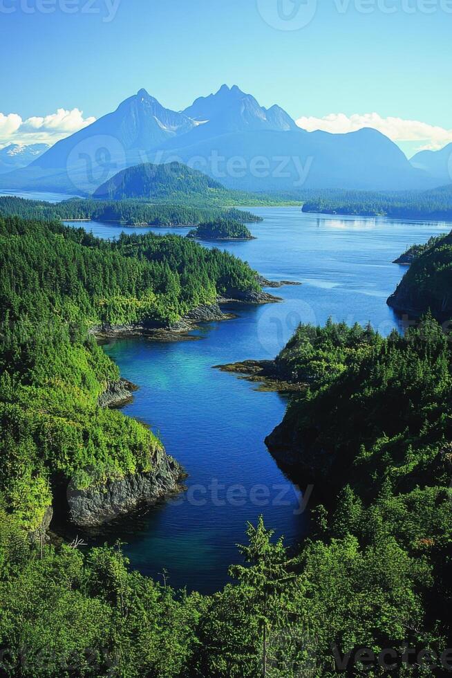 Mountain peaks above forested isles and blue inlet. View from above scenic landscape. Green trees frame water and rocky shores on bright summer day. photo