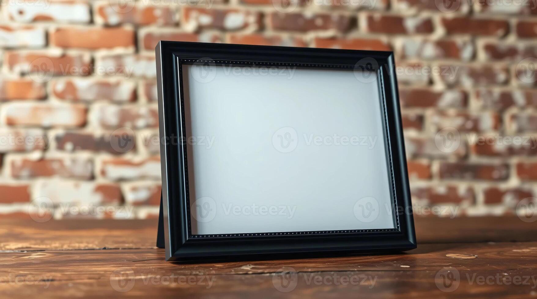 A black frame on a wooden table with a brick wall photo