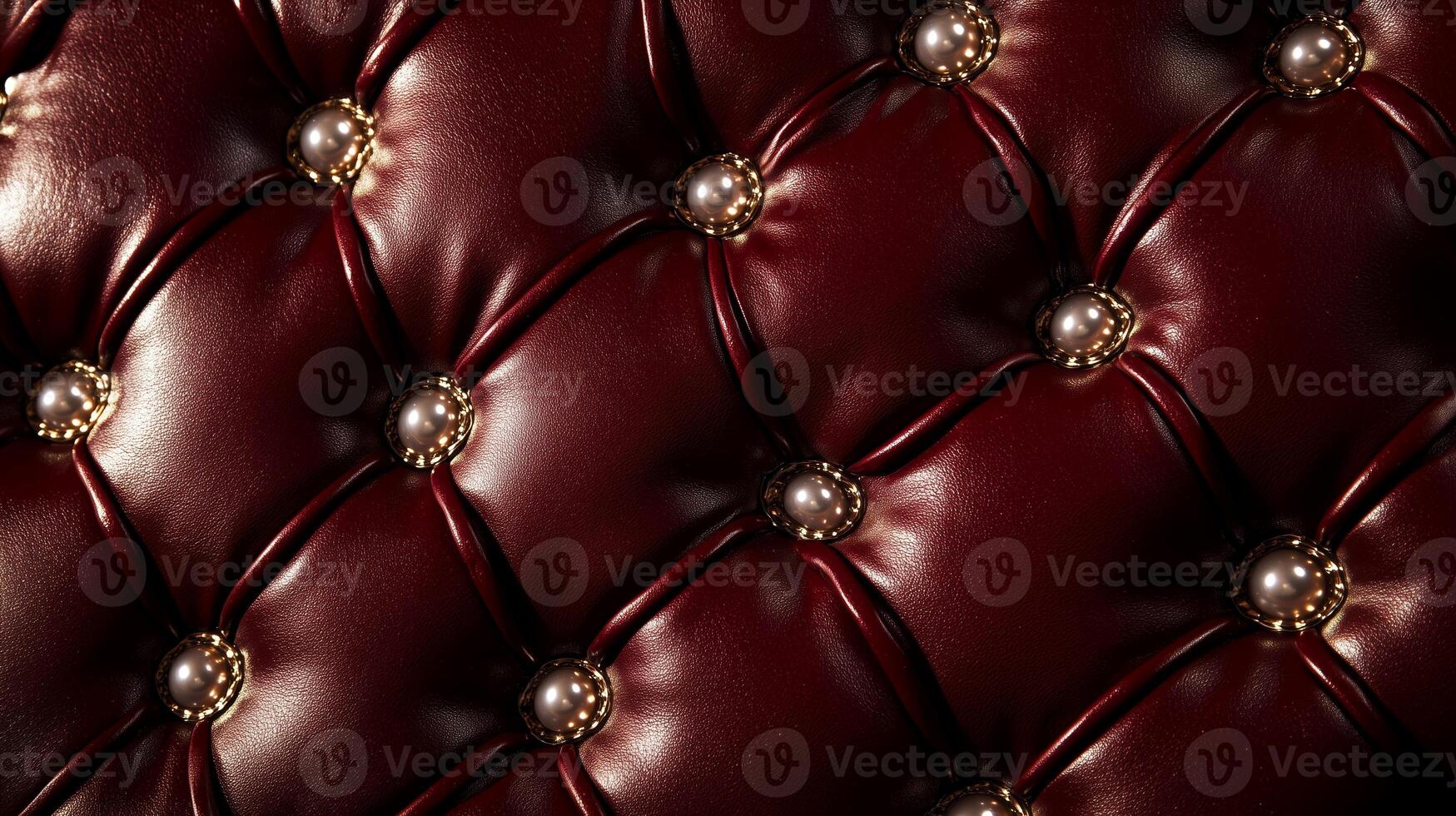 A close up of a red leather couch with gold buttons photo