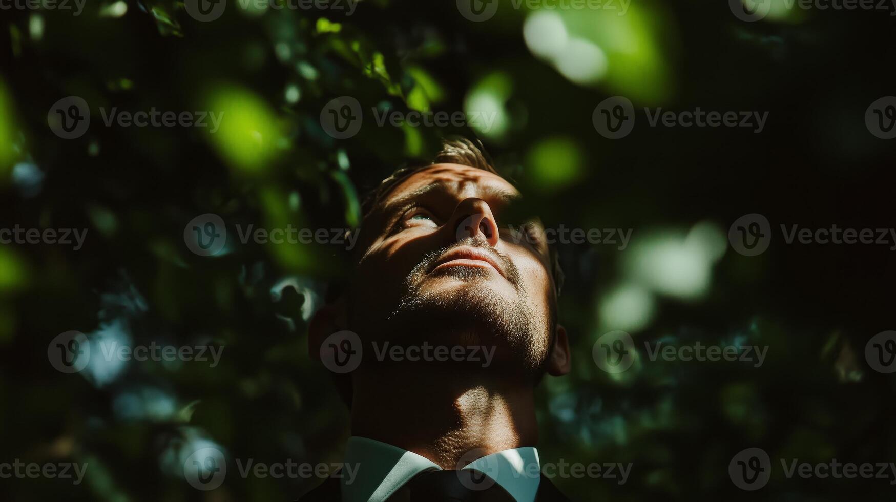 A man in a suit and tie looking up at the sky photo