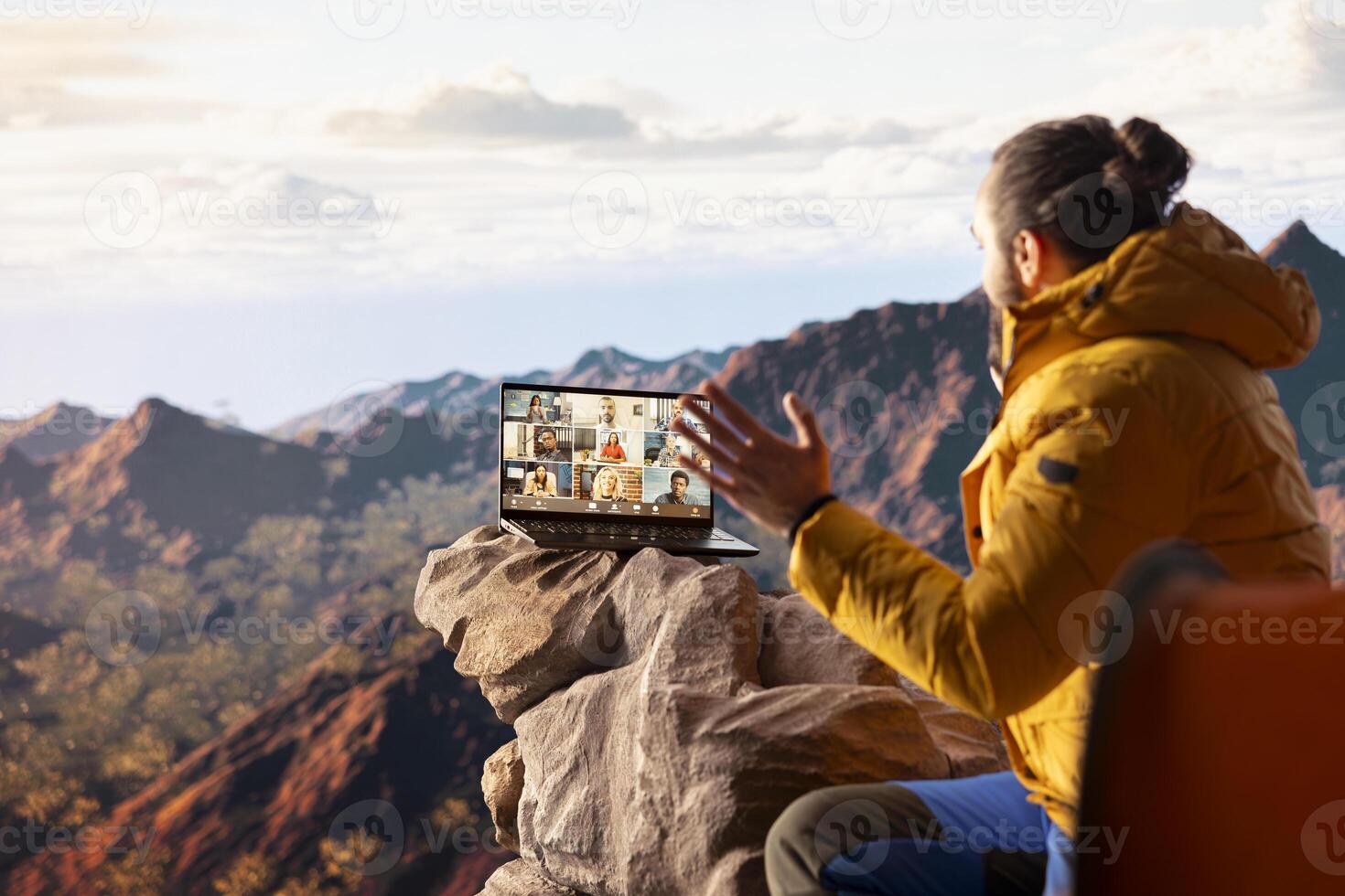 Adventure seeker employee meeting with workmates on call, enjoying strong signal at internet on top of the mountain. Male explorer entrepreneur with technology dependency. photo