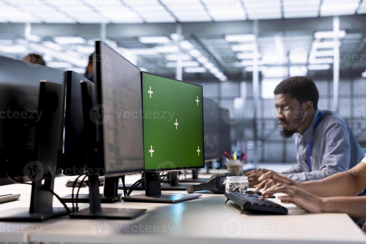Engineer in server hub ensuring data remains shielded from potential threats using green screen PC. Employee safeguarding data center hardware against malicious access with mockup computer display photo