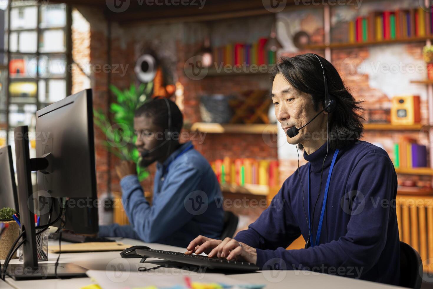Team of call center agents cooperating to provide step by step guidance to customers, talking in headset mic. Coworkers doing customer support job working together, walking clients through fixes photo
