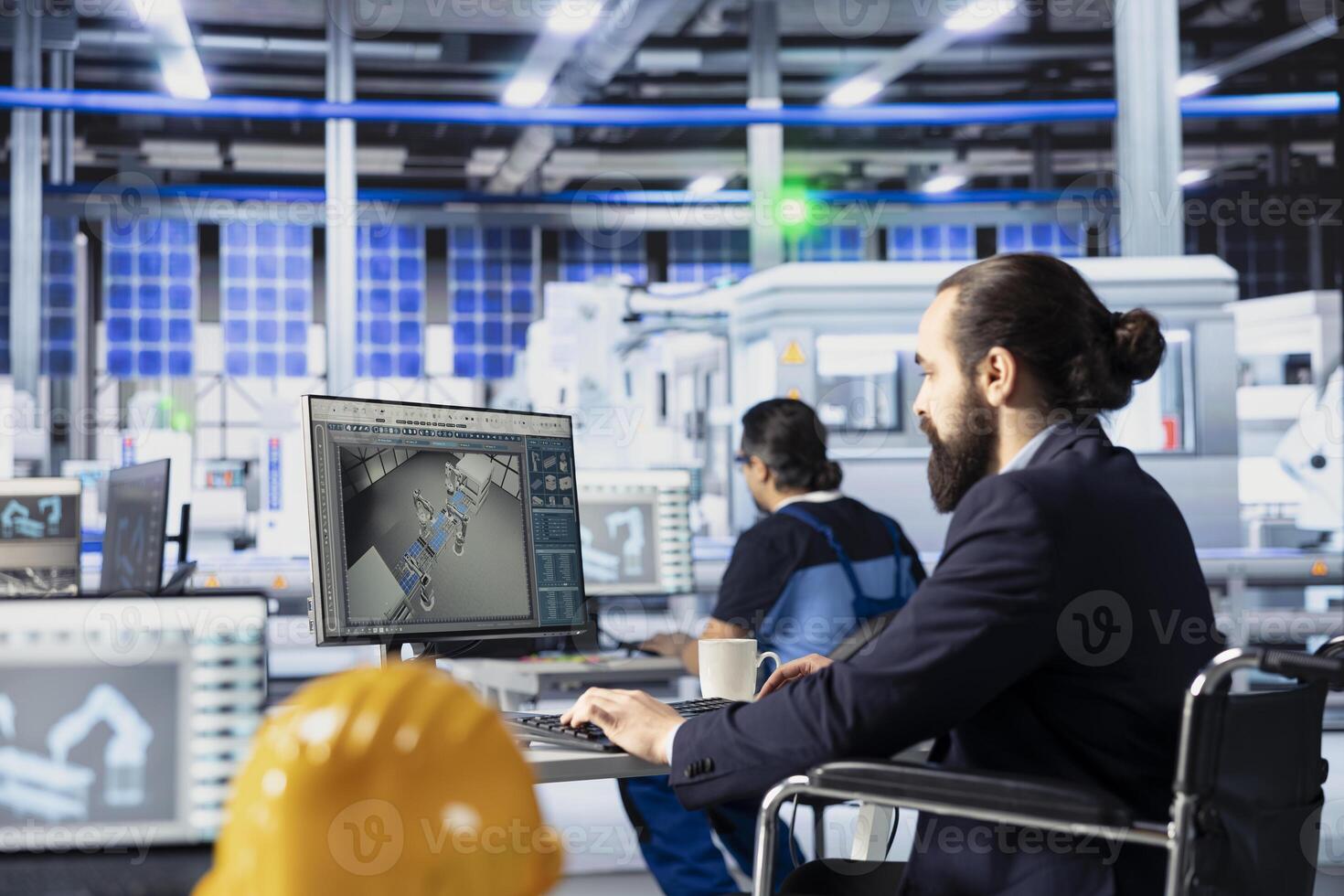 Photovoltaics factory staff member with paraplegia in wheelchair using PC to monitor performance of solar panels manufacturing. Person with disability inspecting solar plant assembly lines on computer photo