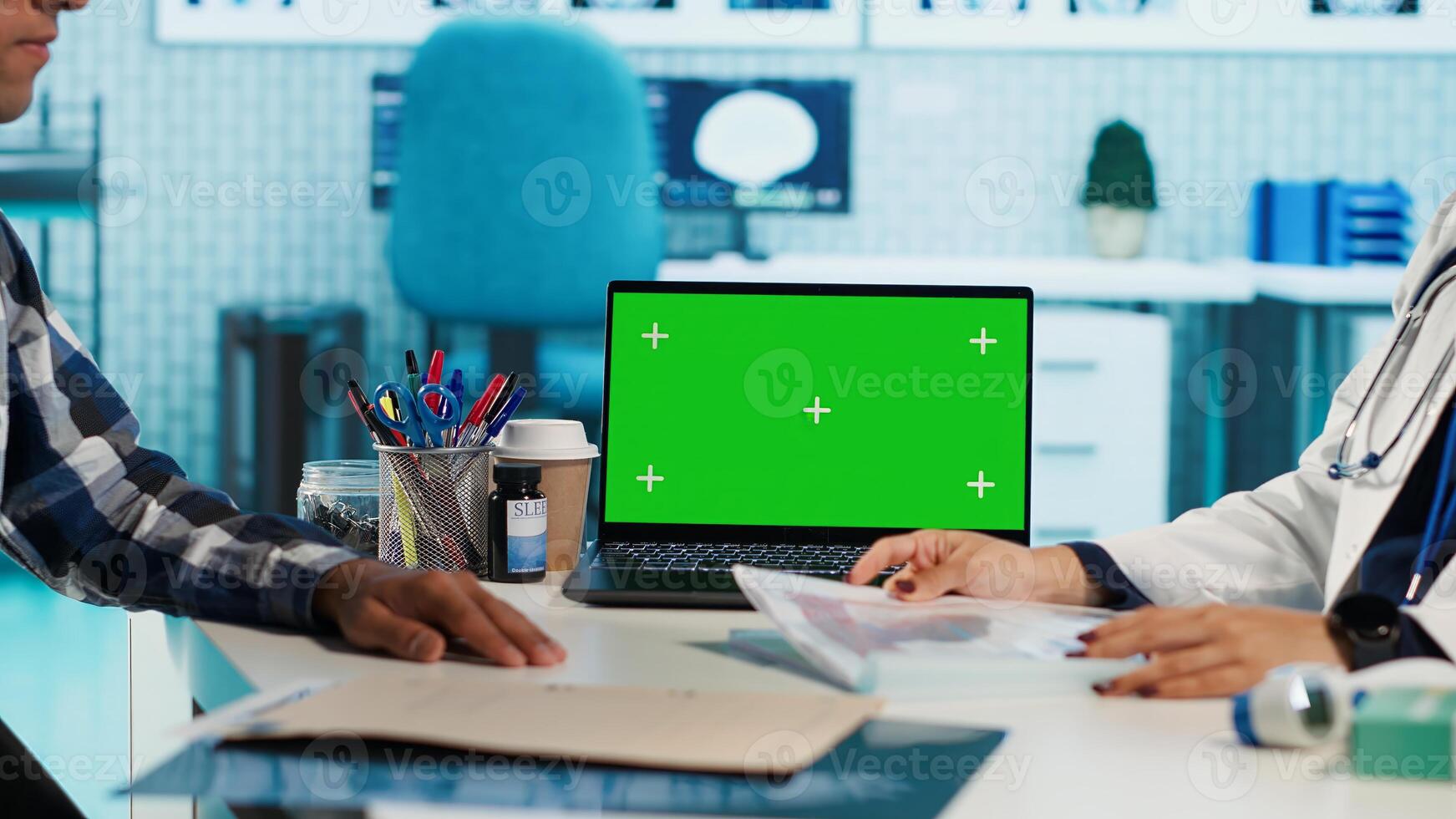 Indian physician consulting a patient in medical facility next to chroma key, using modern tech for scan interpretation and results. Medic giving professional advice based on records. Camera A. photo