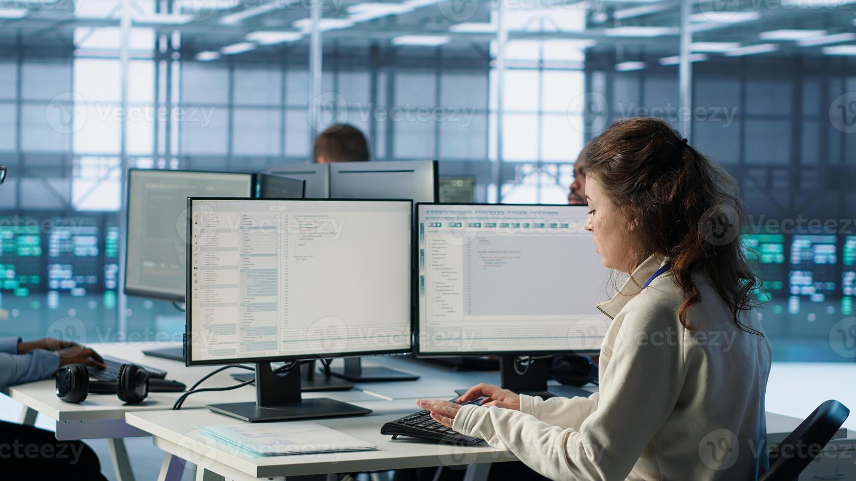 Manager supervising multiethnic team working in data center, making announcement. Team leader discussing with employees monitoring energy consumption across server rigs components, camera A photo