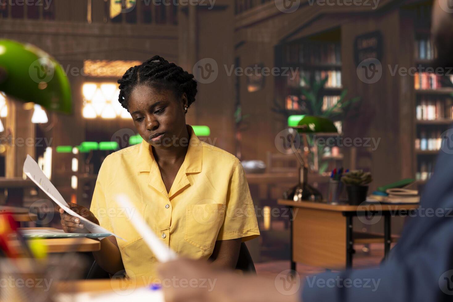 Students team read through an academic project in a vintage library, showcasing their commitment to education and self improvement. Black pupils work together on their academic growth. photo