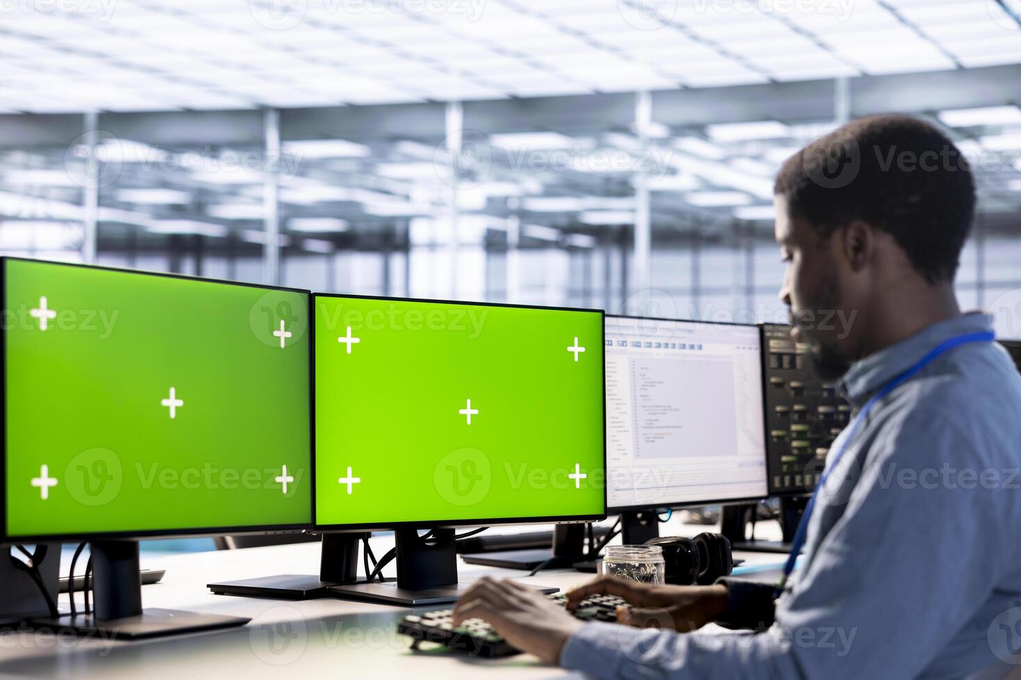 Employee using isolated screen PC to check for signs of failure in data center supercomputers. Engineer working at multi monitor chroma key PC to prevent damages in server farm, monitoring systems photo
