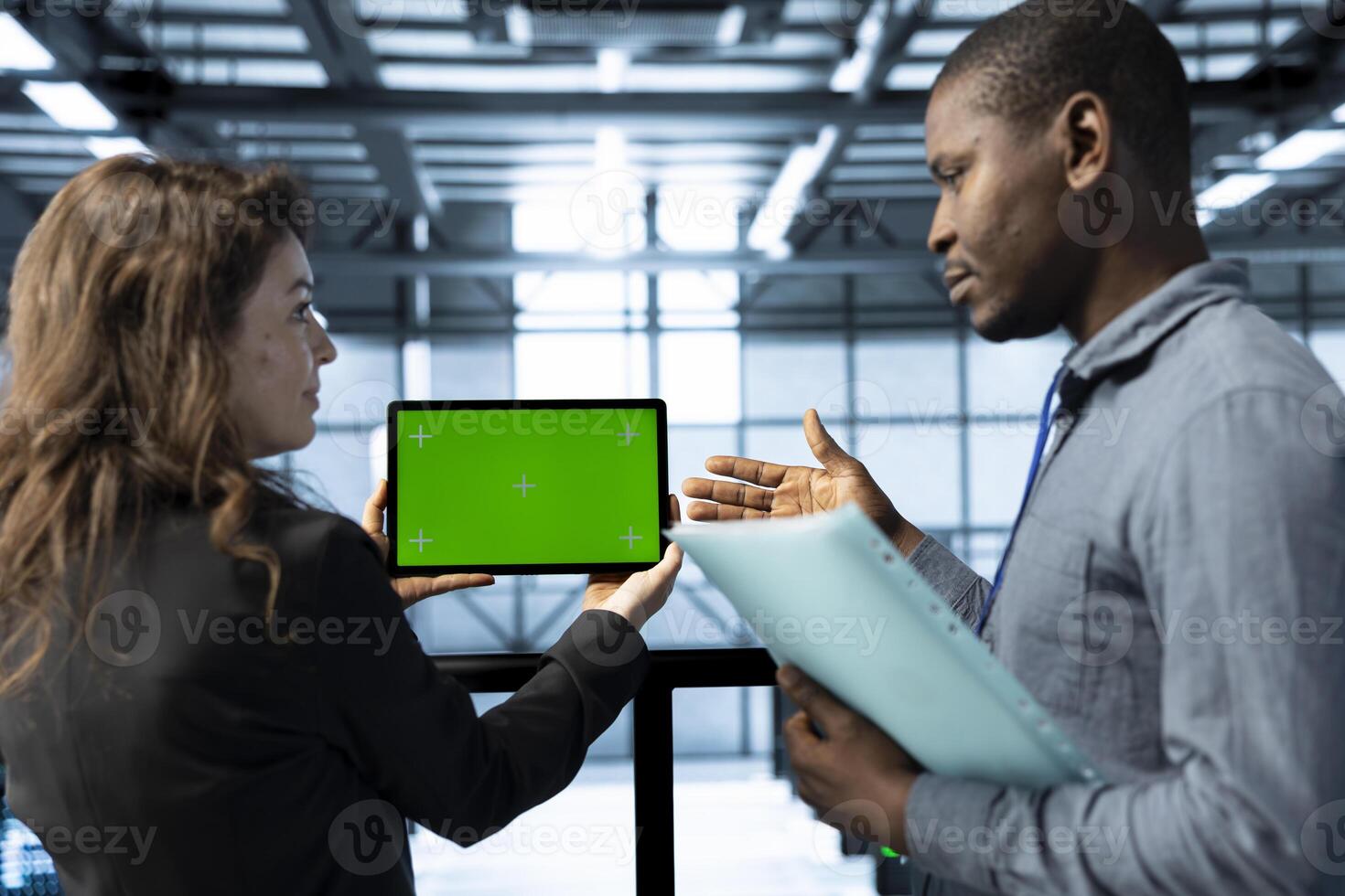Admins in data center using mockup tablet, observing analytics, reviewing infrastructure health. Server hub IT coworkers discussing, using chroma key device, adjusting system parameters photo
