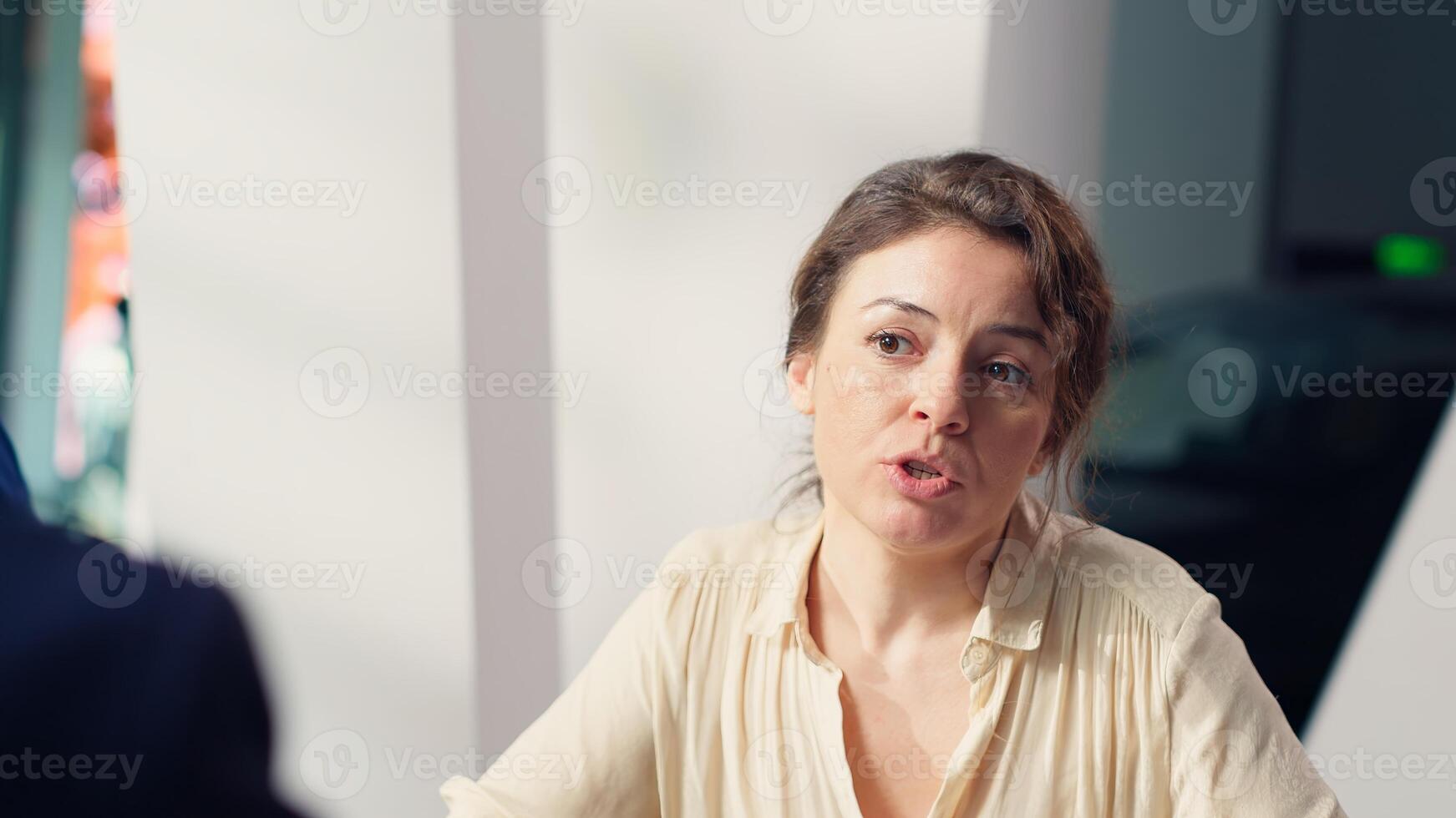 Client in car showroom deliberating purchase, negotiating with salesperson to reduce final price before deciding to sign contract. Woman in dealership debating whether to make vehicle sale, camera A photo