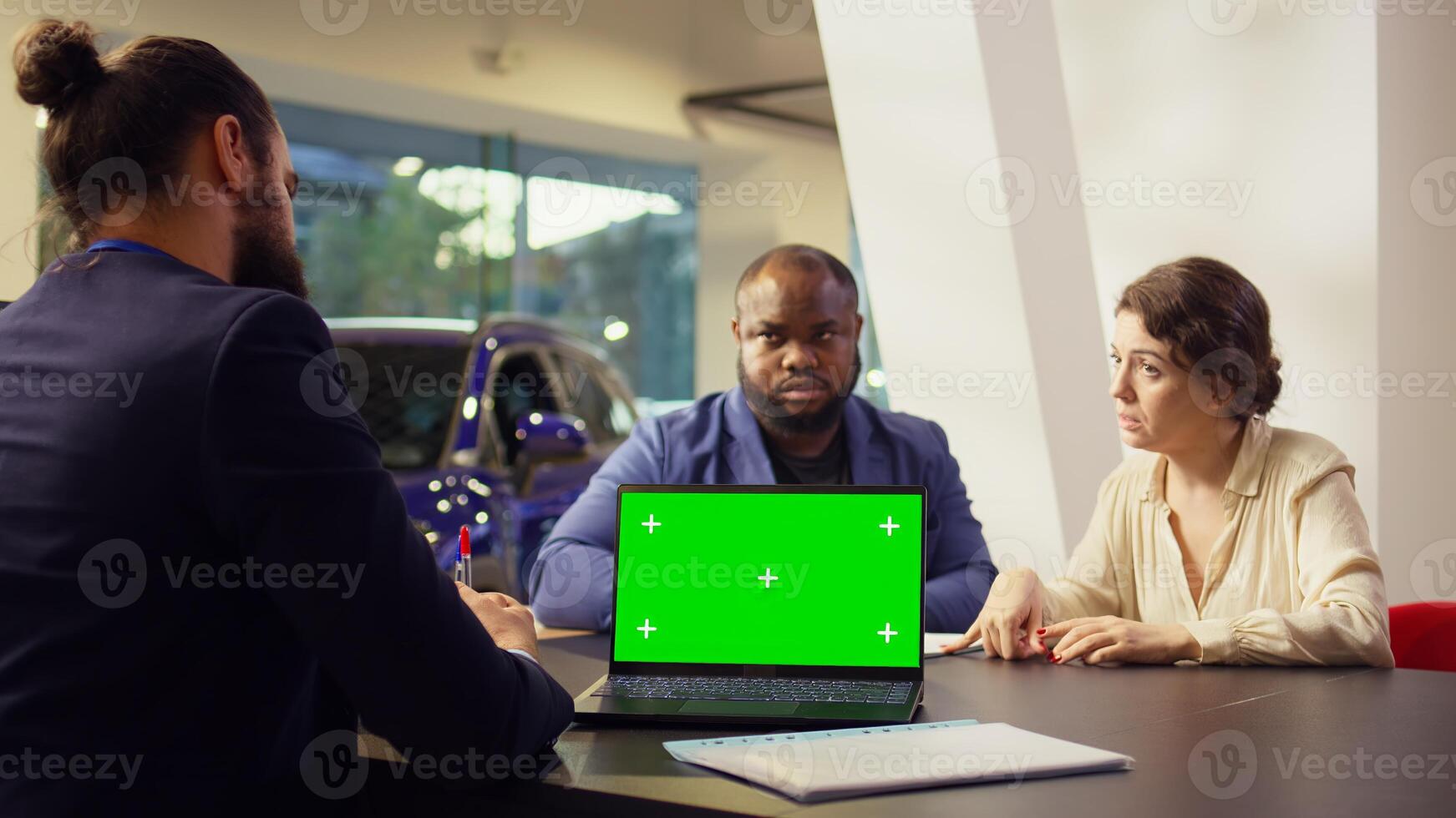 Dealership salesman looking over appointment list on chroma key laptop spreadsheet to schedule car test drive. Showroom agent arranging meeting with clients using isolated screen notebook, camera B photo