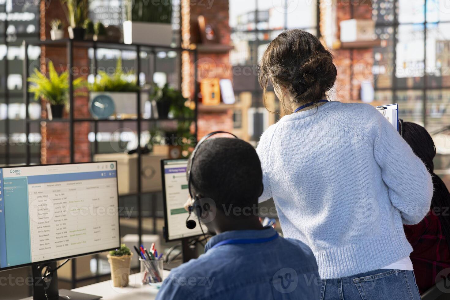 Customer service manager supervising agents logging customer interactions in CSM system. Call center supervisor overseeing workers using customer service management software photo