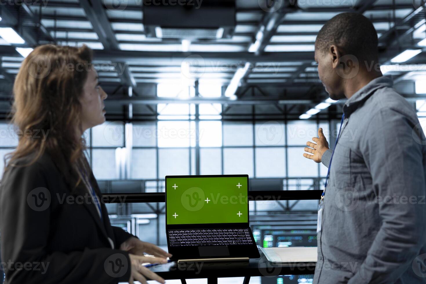 Team of server farm engineers using isolated screen mockup laptop, conducting security audits, preventing errors. IT professionals in data center reviewing firewall rules on chroma key device photo