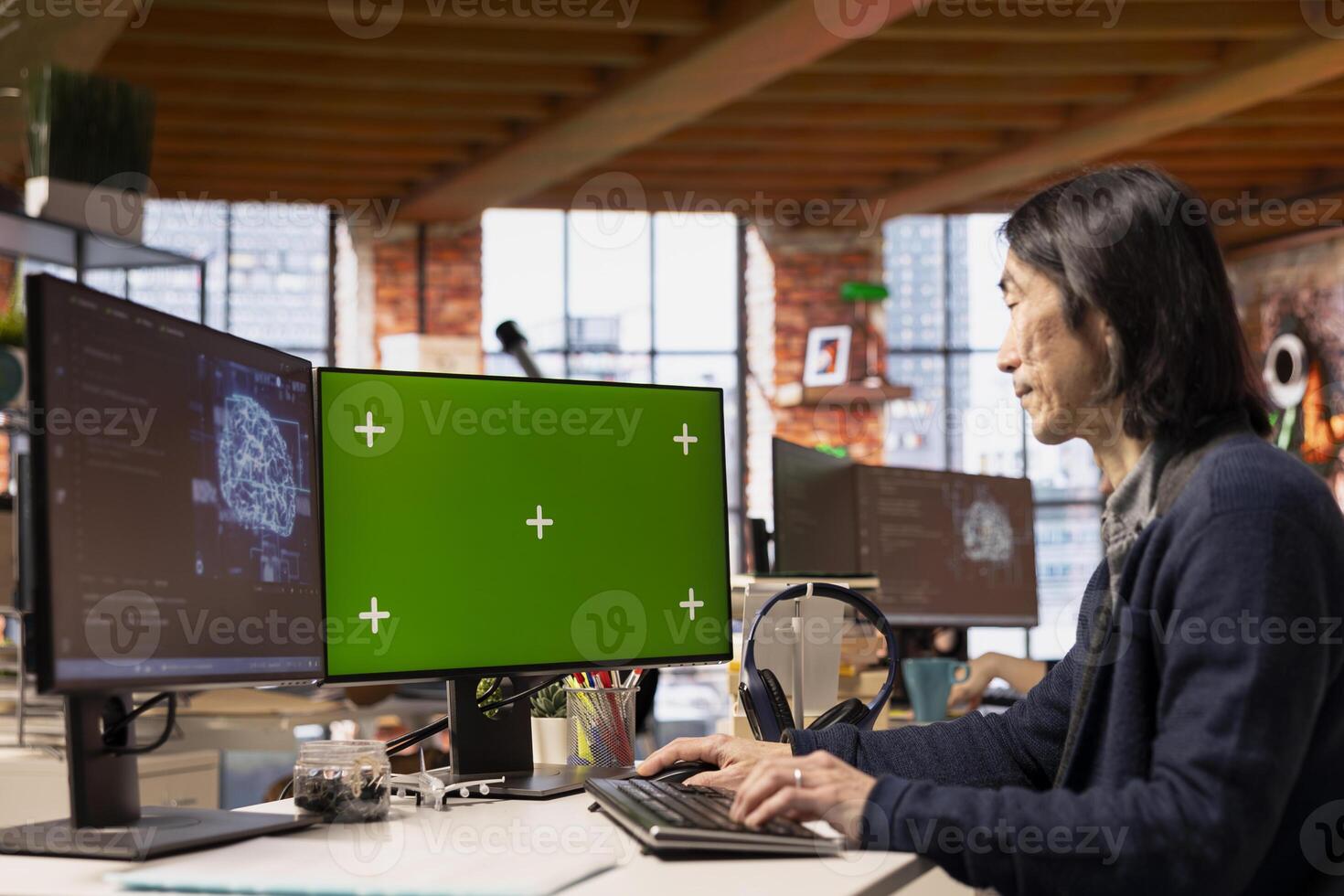 Senior developer using mockup PC in artificial intelligence focused startup, debugging applications. Experienced IT expert doing code testing and quality assurance on green screen computer photo