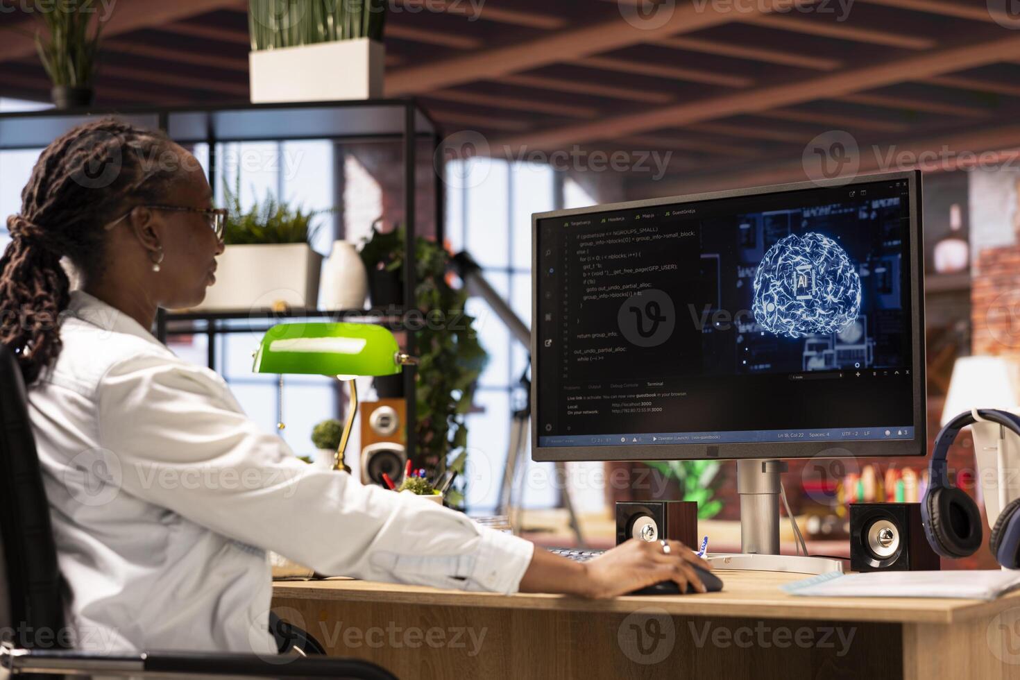 Freelancing computer engineer doing maintenance on artificial intelligence systems, sitting at apartment office desk. African american IT specialist at working from home, doing checkup on AI systems photo