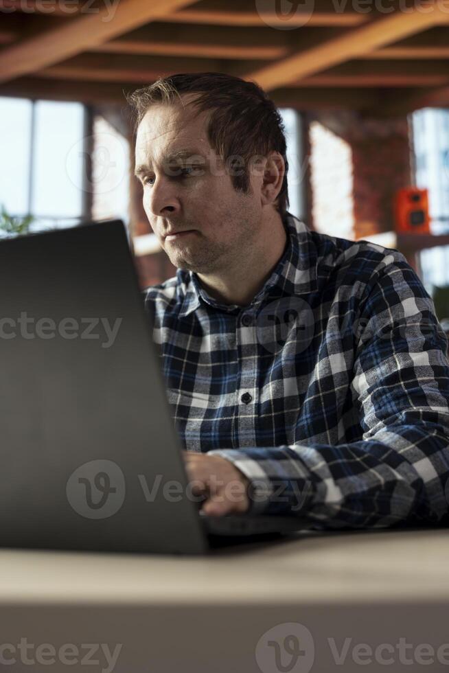 Person in home office analyzing data charts on notebook, interpreting statistical graphs, identifying trends. Freelancer typing on laptop keyboard, compiling analytical reports, processing data photo