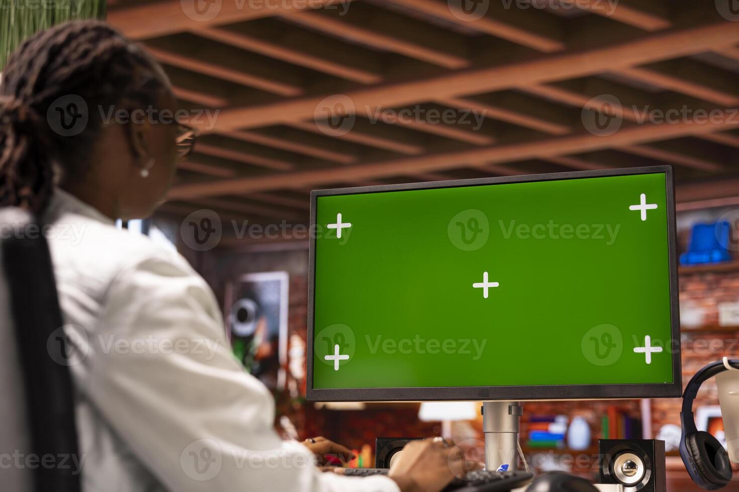 Woman inputting data on chroma key PC, completing spreadsheets in home office. African american person editing documents on isolated screen computer, updating reports and files photo