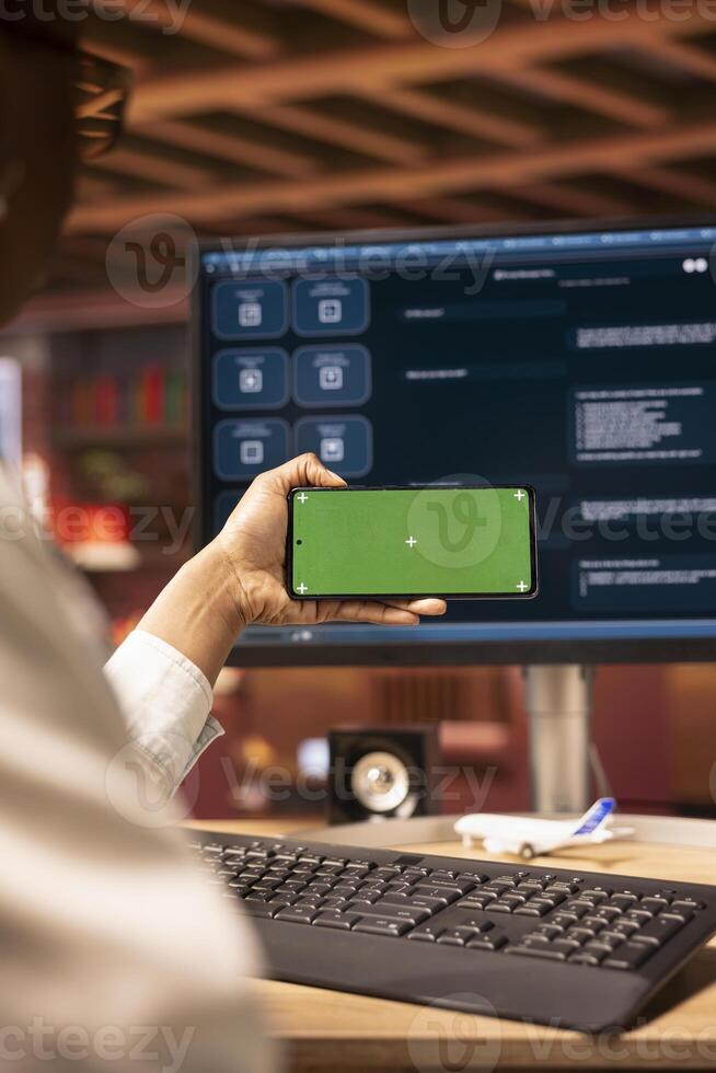 Woman using isolated screen mobile phone to look at tutorials about AI chatbots, closeup. Person holding chroma key smartphone to look at visual guides on artificial intelligence LLMs photo