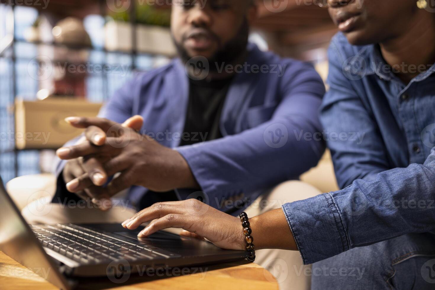 African American couple in their home space collaborate on a business project, using teamwork and digital online tools to enhance efficiency and career growth. Solving freelancing tasks. photo