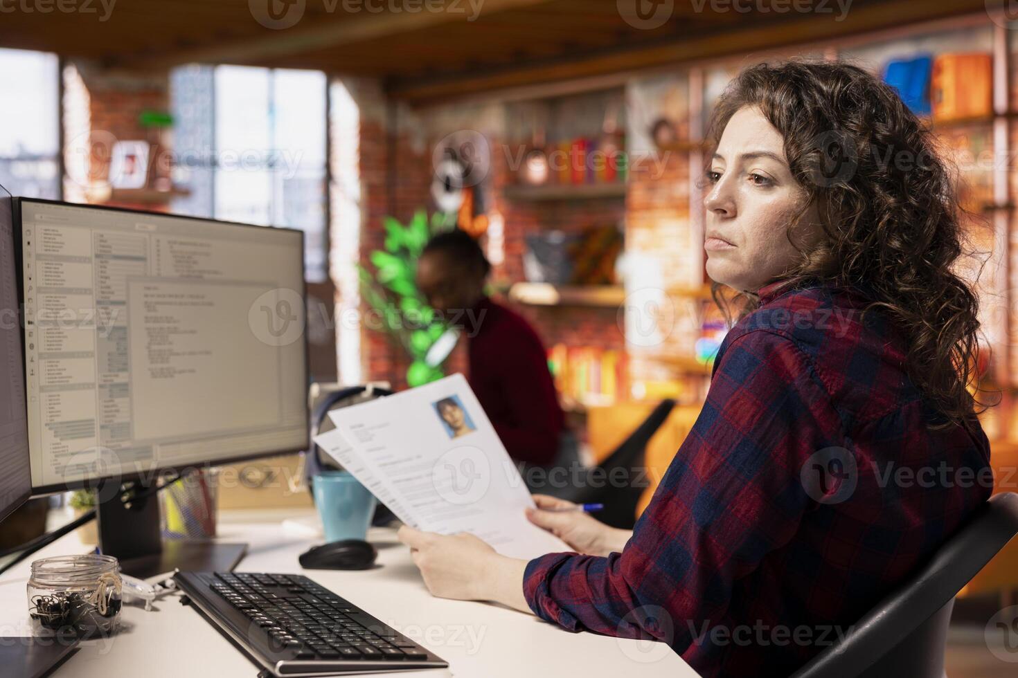 Tech startup HR employee identifying candidates for job opening, reviewing resumes to determine skills. Woman screening people for software development Silicon Valley company position photo