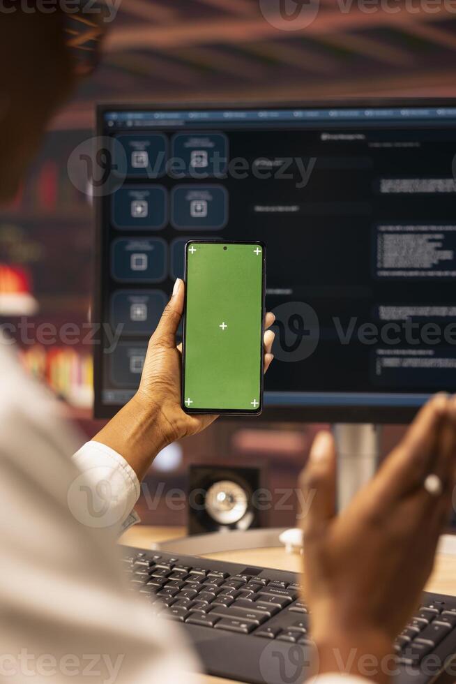 Woman sending vocal commands to AI LLM chatbot on PC using isolated screen smartphone. Close up of person speaking in mockup phone to communicate with artificial intelligence chatbot on computer photo