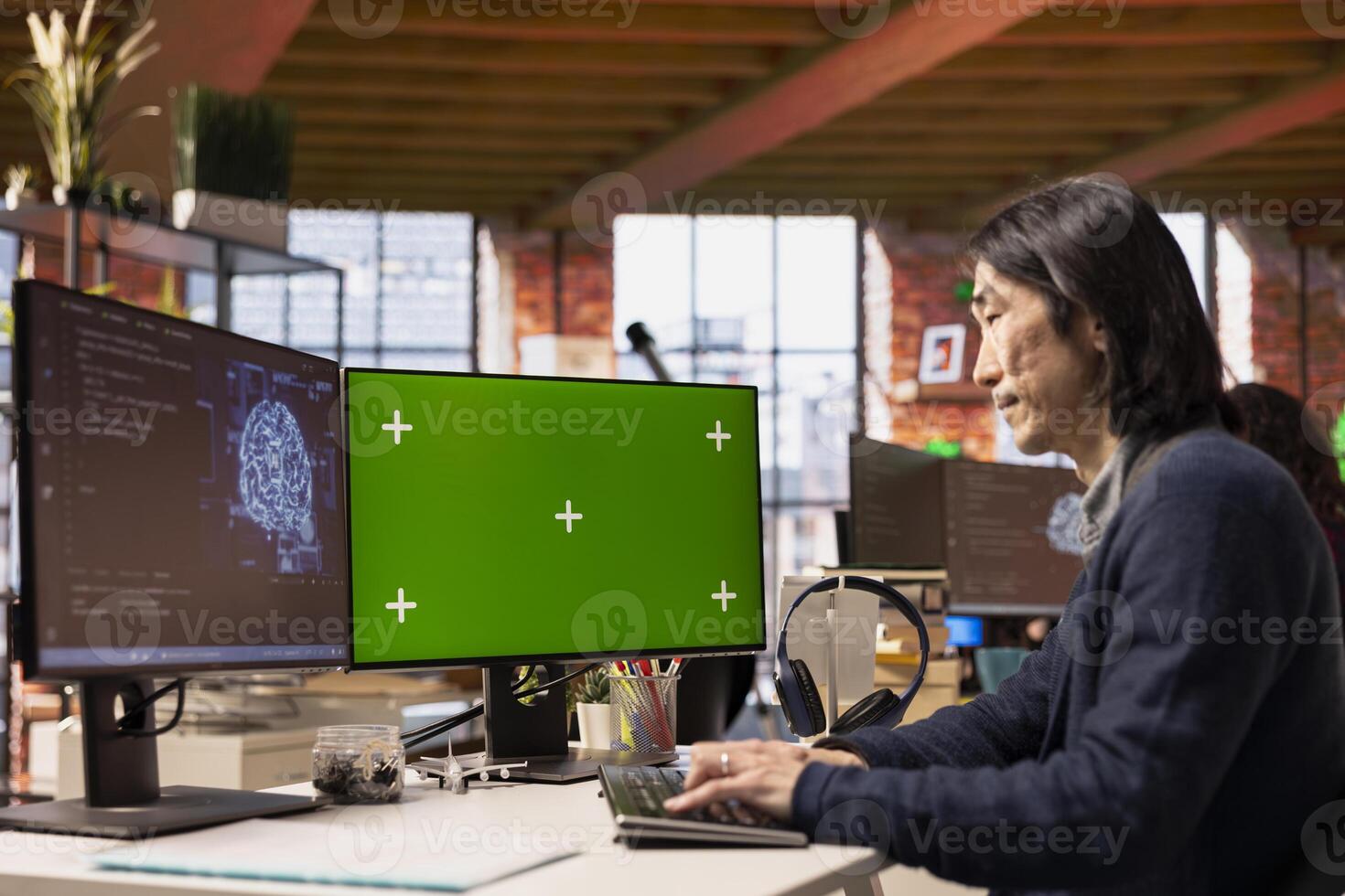 Software developer in pioneering technology startup using green screen computer to oversee artificial intelligence neural networks. Man in tech startup office using AI to build product on mockup PC photo