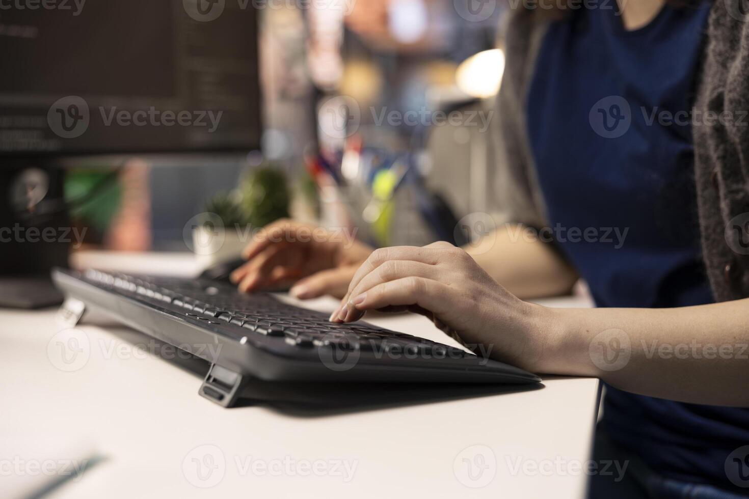 Young woman at the office looking at UI on PC display and executing binary code for testing and implementing something on the software. Coding application for computer science. Close up. photo