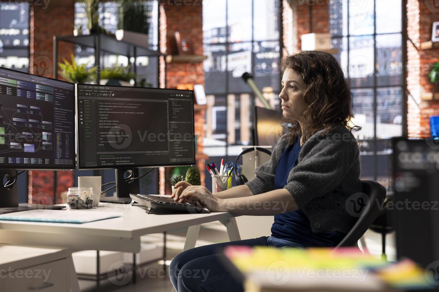 Software developer at agency office coding on her computer creating a software and works on implementing algorithms. IT expert building applications with a programming interface. photo