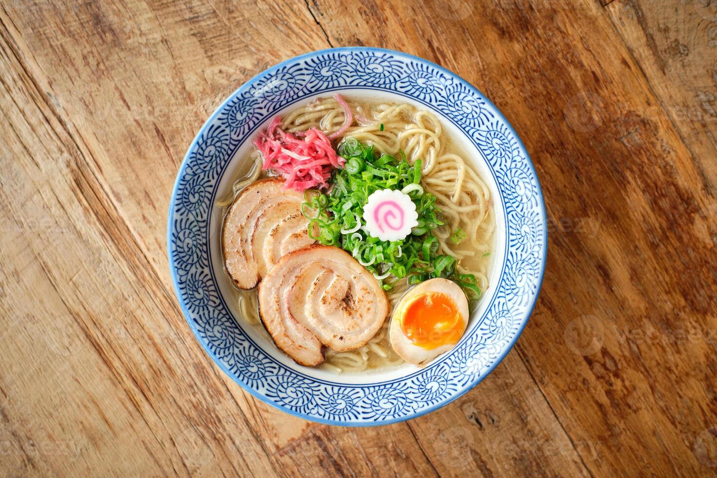 Delicious ramen soup with soft egg and pork meat in bowl photo