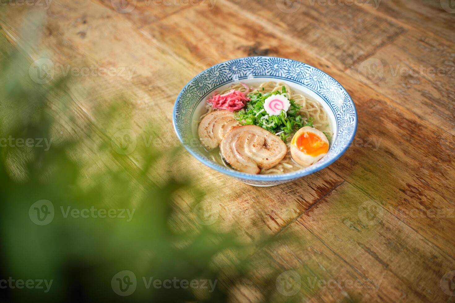 Delicious ramen soup with soft egg and pork meat in bowl photo