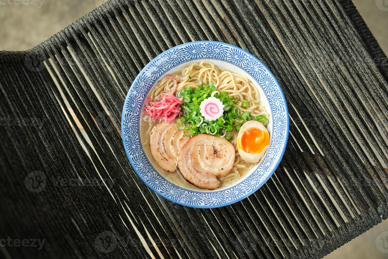 Delicious ramen soup with soft egg and pork meat in bowl photo
