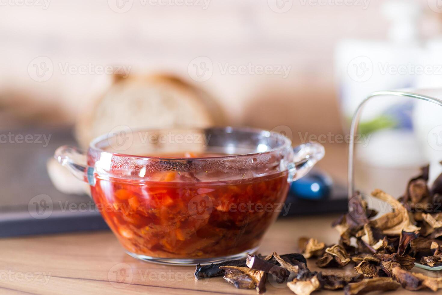Mushroom lunch.hot lean vegetable soup with beets and dried mushrooms on a wooden table photo
