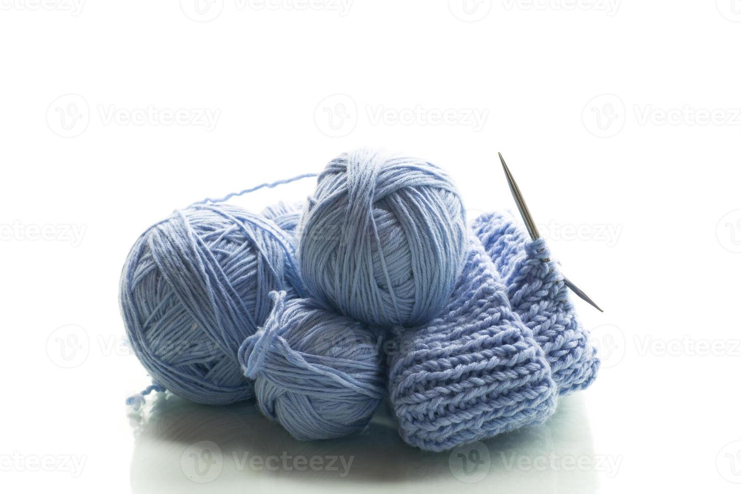 Balls of thread for knitting.Blue yarn with knitting, isolated on white background photo