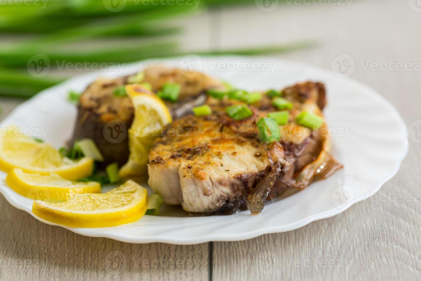 Baked piece of fish. Baked fish with lemon and herbs photo