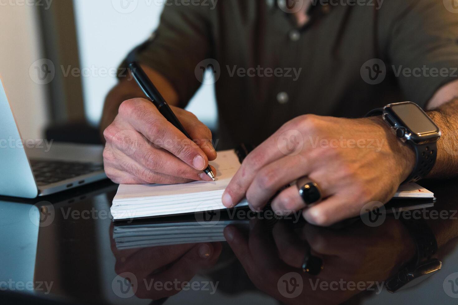 Anonymous man writing in notebook photo