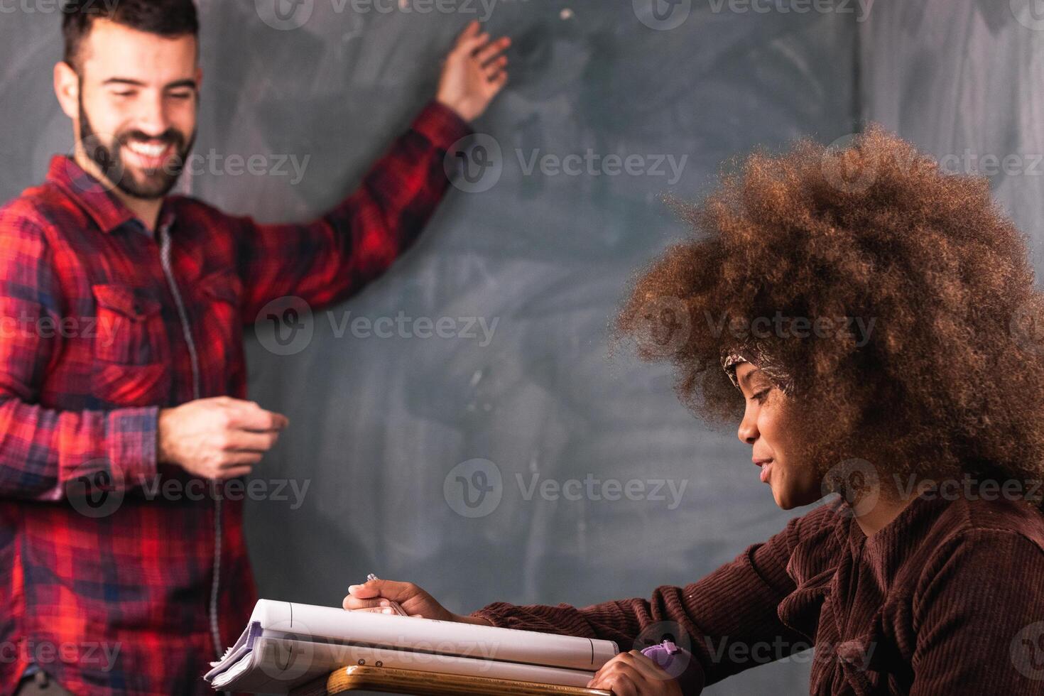 Multiracial teacher and pupil in classroom at math lesson photo