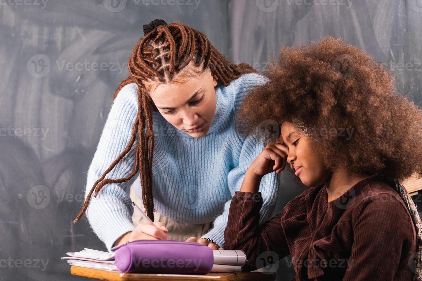 Black schoolgirl and teacher in classroom photo